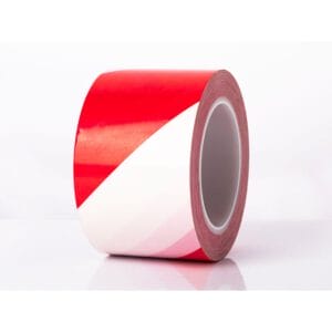 Verkehrsband Extra: Rolle Klebeband mit rot-weißen Diagonalstreifen, liegt auf weißem Hintergrund, Absperrband erkennen.