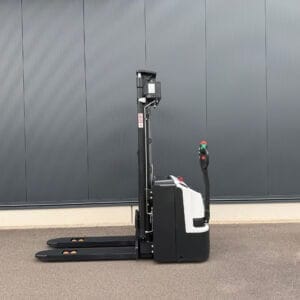 Bobcat Elektro Hochhubwagen BSL12N-i mit angehobenen Gabeln steht auf Pflaster vor glatter, grauer Industriehallenwand.