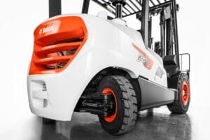 Niederwinkel-Nahaufnahme eines weißen und orangen Gabelstaplers Bobcat D50 mit großen Reifen und sauberer Karosserie.