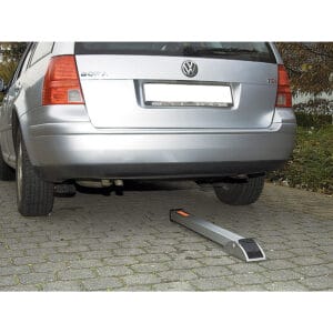 Silberner Volkswagen Bora parkt auf Kopfsteinpflaster, hinter den Hinterrädern eine SESAM-SPRINT Kipp-Pfosten Parkplatzsperre.