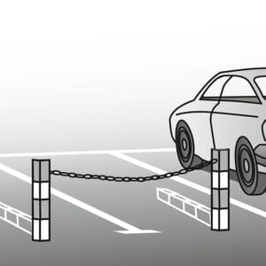 Auto neben freiem Parkplatz, gesichert durch SESAM-B Kettenabsperrung zwischen zwei Pfosten auf einem Parkplatz.