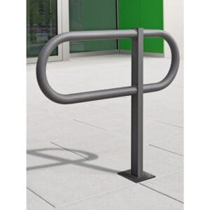 Fahrradständer Anlehnbügel TOUR aus Metall, oval, auf hellen Fliesen vorm Gebäude mit grünen und weißen Wänden, Glastüren.