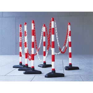 Sechs Kettenständer mit rot-weißen Streifen, in zwei Reihen auf Fliesenboden, durch Ketten verbunden, Indoor-Aufstellung.
