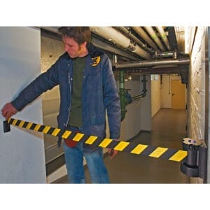 Ein Mann steht im Flur und hält den MORION Wandgurt; moderne Innenarchitektur, Sicherheitsgurt an der Wand befestigt.