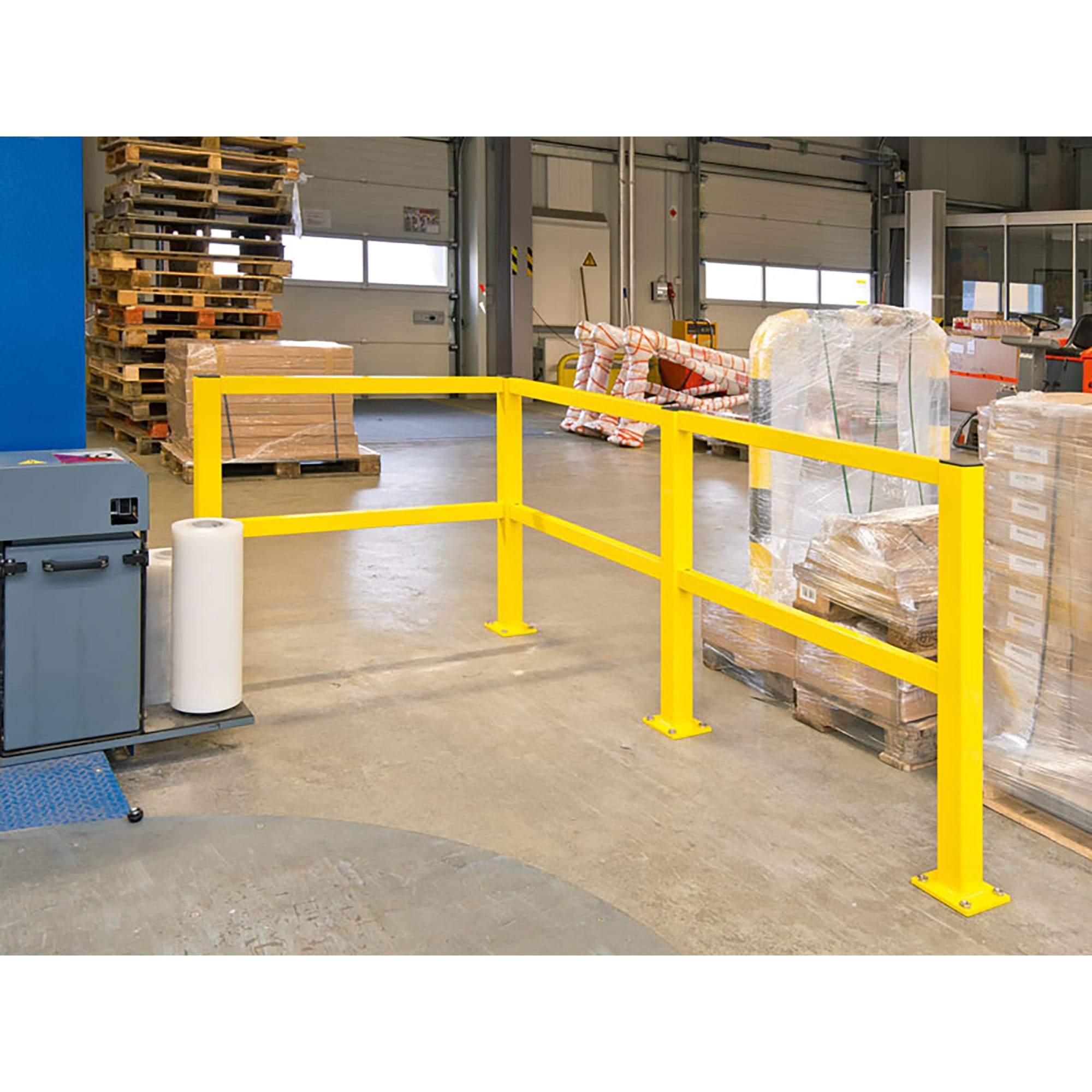 Gelbes Rammschutzgeländer S-line aus Metall von BLACK BULL in Lagerhalle, neben Paletten, Kisten und Geräten auf Betonboden.