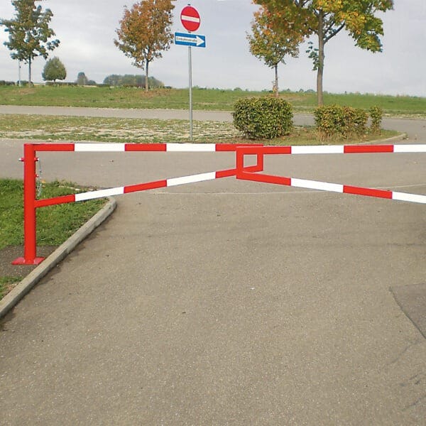 MORION Gatterschranke rot-weiß sperrt Zufahrt zu Asphaltstraße, Durchfahrt verboten Schild, Bäume im Hintergrund.