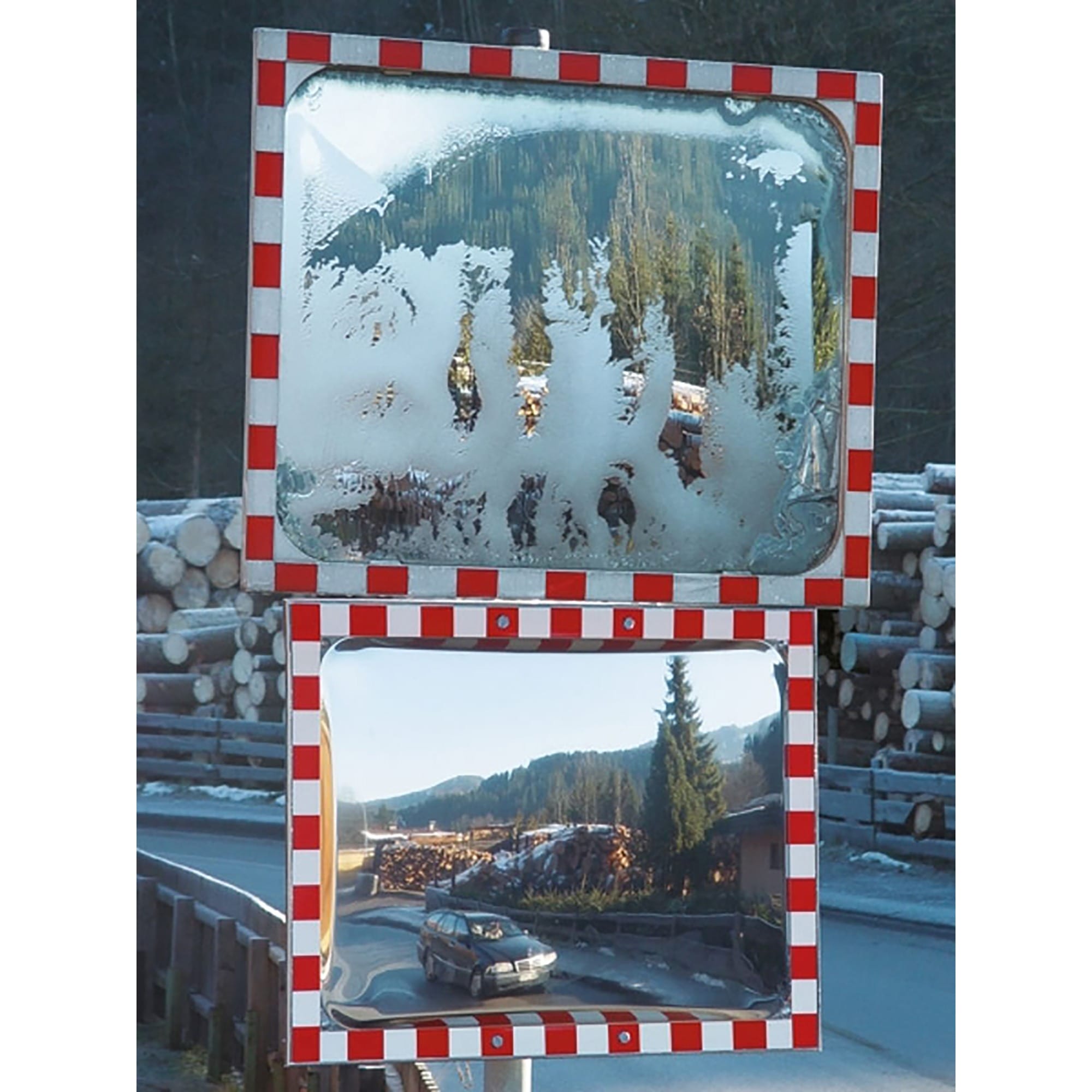 Zwei DURABEL IceFree PRO Verkehrsspiegel zeigen Bergwald; oberer Spiegel teilweise beschlagen, unterer Auto und Stapel Holz am Straßenrand.