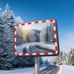 DURABEL IceFree PRO Verkehrsspiegel mit rot-weißem Rahmen zeigt verschneite Straßen und Bäume in winterlicher Schneelandschaft.