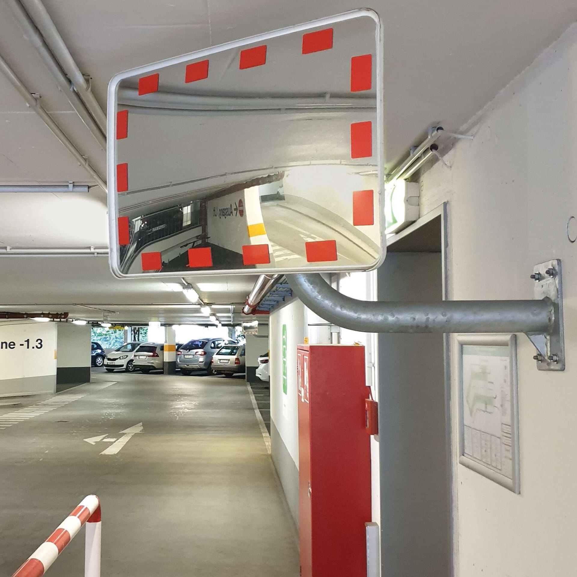 Rechteckiger EUCRYL ECO Verkehrsspiegel mit roten Markierungen in Tiefgarage, zeigt parkende Autos und Garagendetails.