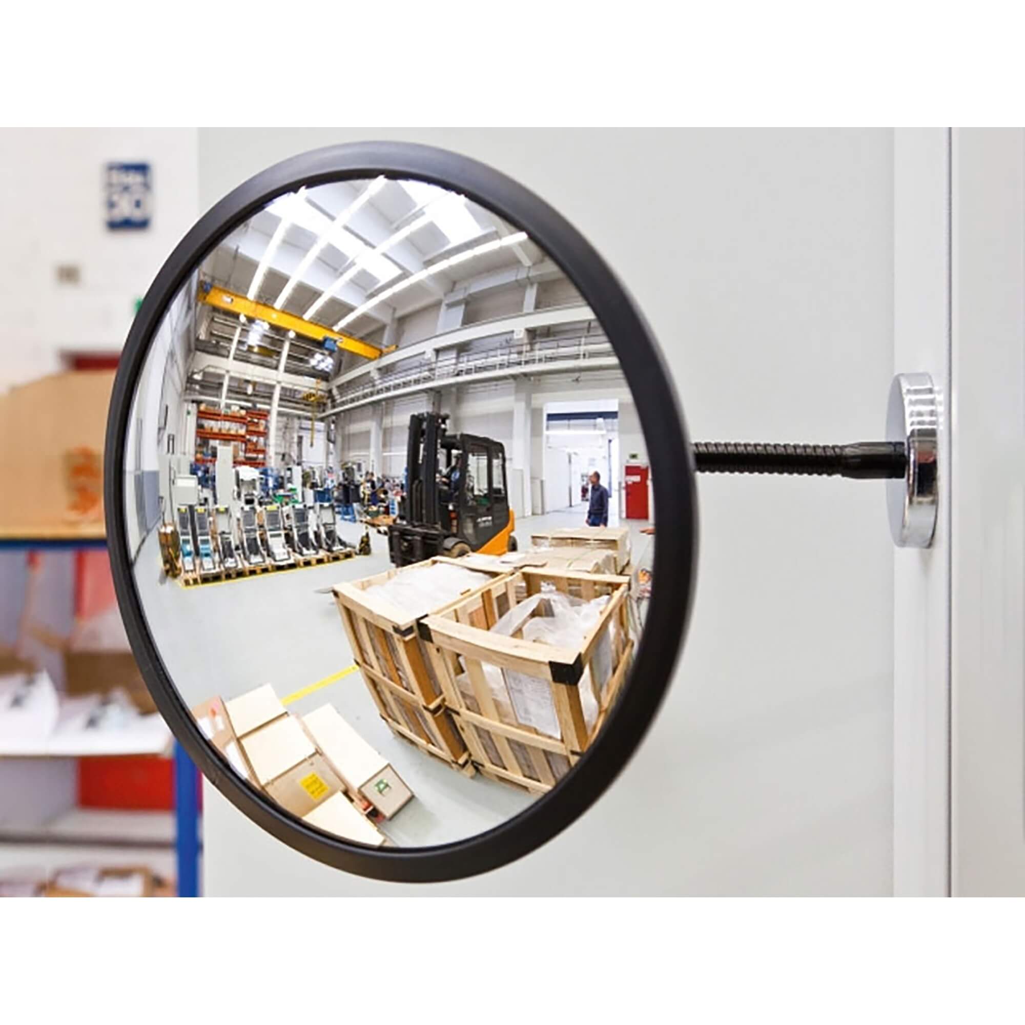 Beobachtungsspiegel mit Magnethalterung an Wand zeigt Spiegelbild von Lagerhalle, Gabelstapler, Holzkisten, Industrieregalen.