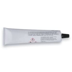 Kantenversiegelung Tube mit schwarzem Deckel, deutscher Beschriftung und Gefahrensymbolen, liegend auf weißem Hintergrund.