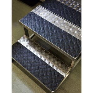 Detailaufnahme Metalltreppe mit rutschfestem Antirutsch-Belag, Tränenblech-Muster und schwarzen Anti-Rutsch-Streifen auf jeder Stufe.