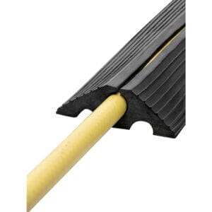 Schwarze MORION Kabelbrücke aus Gummi mit gelbem Kabel in einem Kanal, schützt Bodenleitungen, rutschfest und stabil.