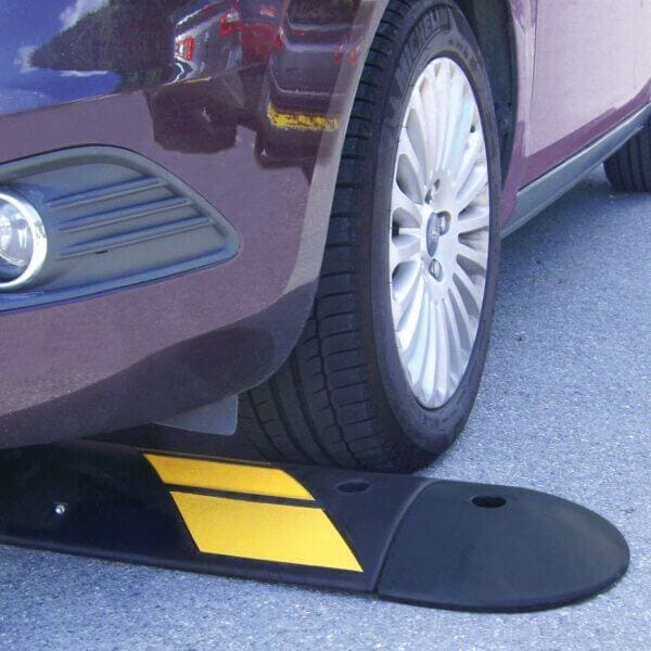 Autoreifen steht auf EasyRide Fahrbahnschwelle, gelb-schwarze Bodenschwelle auf Asphaltstraße, Verkehrssicherheit.