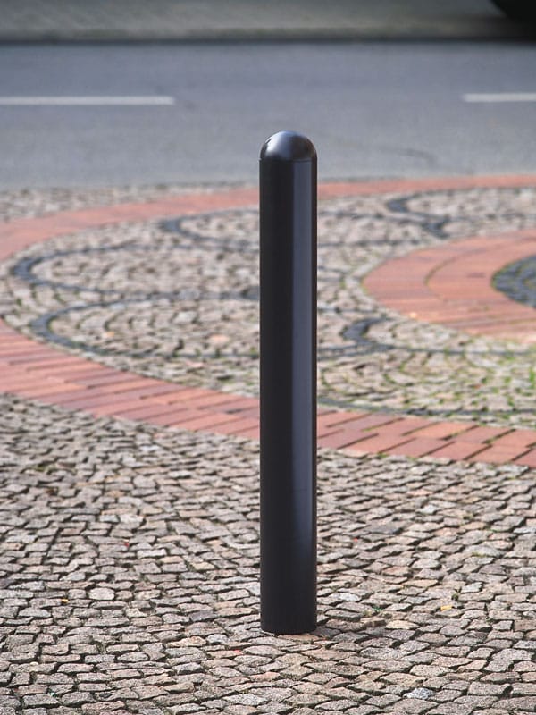 Schwarzer City-Poller WIEN 76 steht auf gemustertem Gehwegpflaster am Straßenrand in einer deutschen Stadt.