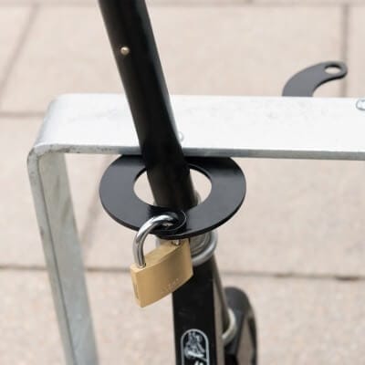 CITY-Scooter-Parker mit rundem Metallring und Vorhängeschloss sichert Ring am Fahrradständer, nicht direkt den E-Scooter.