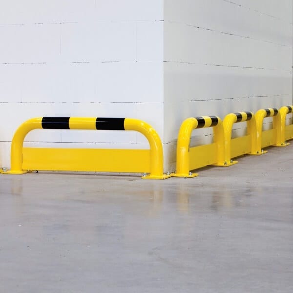 BLACK BULL Rammschutz-Bügel mit Unterfahrschutz am Sockel einer weißen Ecke auf Betonboden montiert.