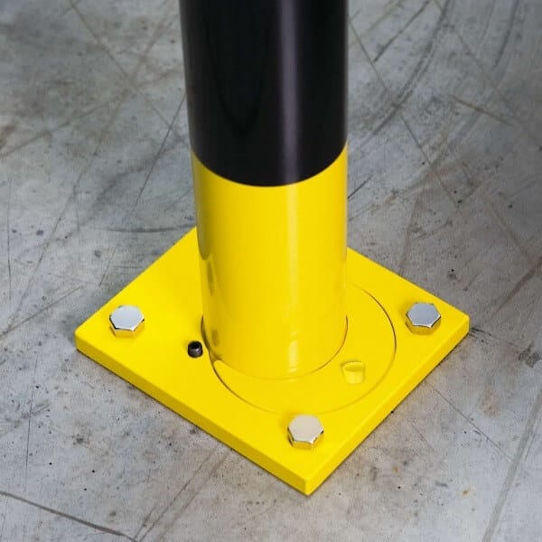 Gelb-schwarzer BLACK BULL Rammschutzbügel mit quadratischer Bodenplatte, befestigt durch vier silberne Betonschrauben.