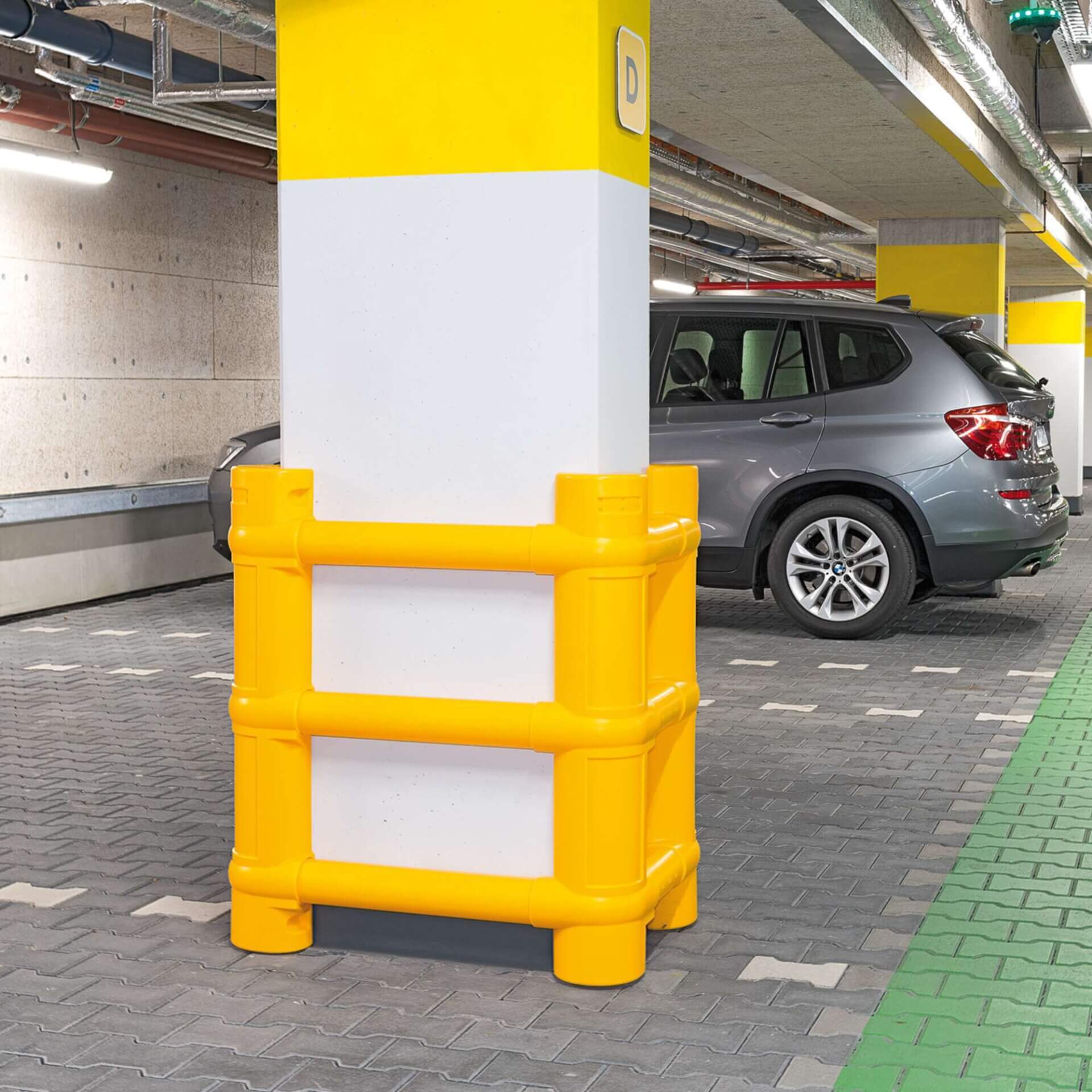 Betonsäule im Parkhaus mit gelbem MORION Säulenschutz aus Kunststoff; grauer SUV parkt auf gepflastertem Boden daneben.