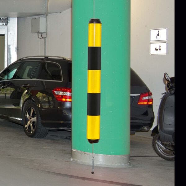 Grüne Säule in Tiefgarage mit gelb-schwarzer LeitPin-Boje Polsterung, geparkten Autos und sichtbaren Wandschildern.