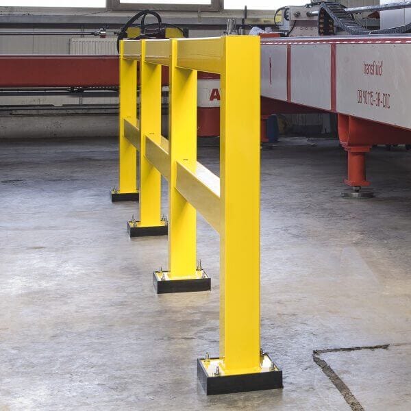 Schwarze PU-Federelement-Schutzbarriere mit drei Pfosten, am Betonboden in einer Industriehalle fest verschraubt.