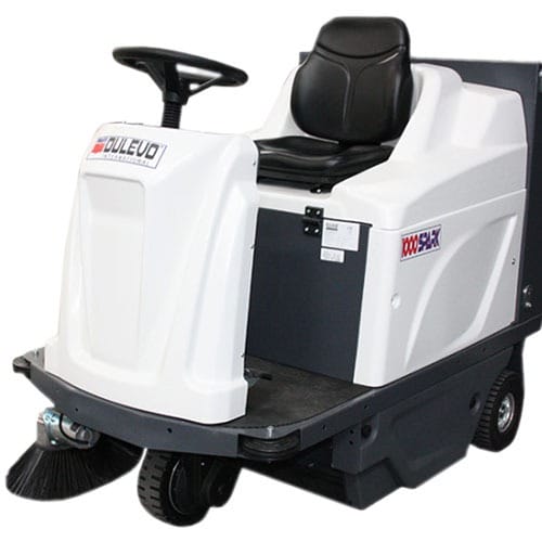 Weiße Aufsitz-Kehrmaschine mit Lenkrad, Fahrersitz und seitlicher Bürste am Vorderrad. Industrielle Bodenreinigung.